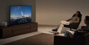 Un couple se détendant devant un film diffusé depuis un serveur NAS compact placé sur un meuble de salon