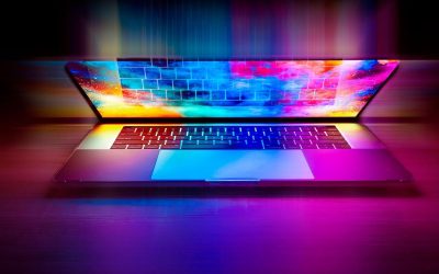 Un ordinateur portable ouvert avec clavier et écran coloré sur table sombre
