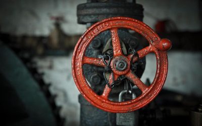 Grande roue rouge de vanne sur tuyau atelier sombre cadenas fixé